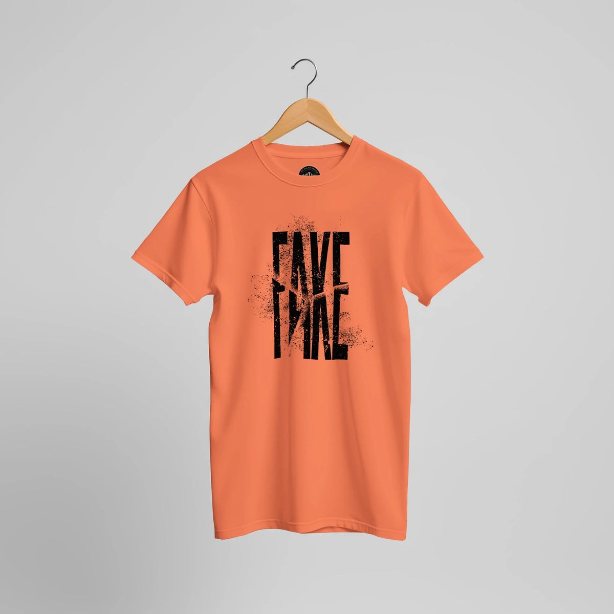 Orangefarbenes T-Shirt mit schwarzem FAKE-Schriftzug im Used-Look, Vorderansicht.